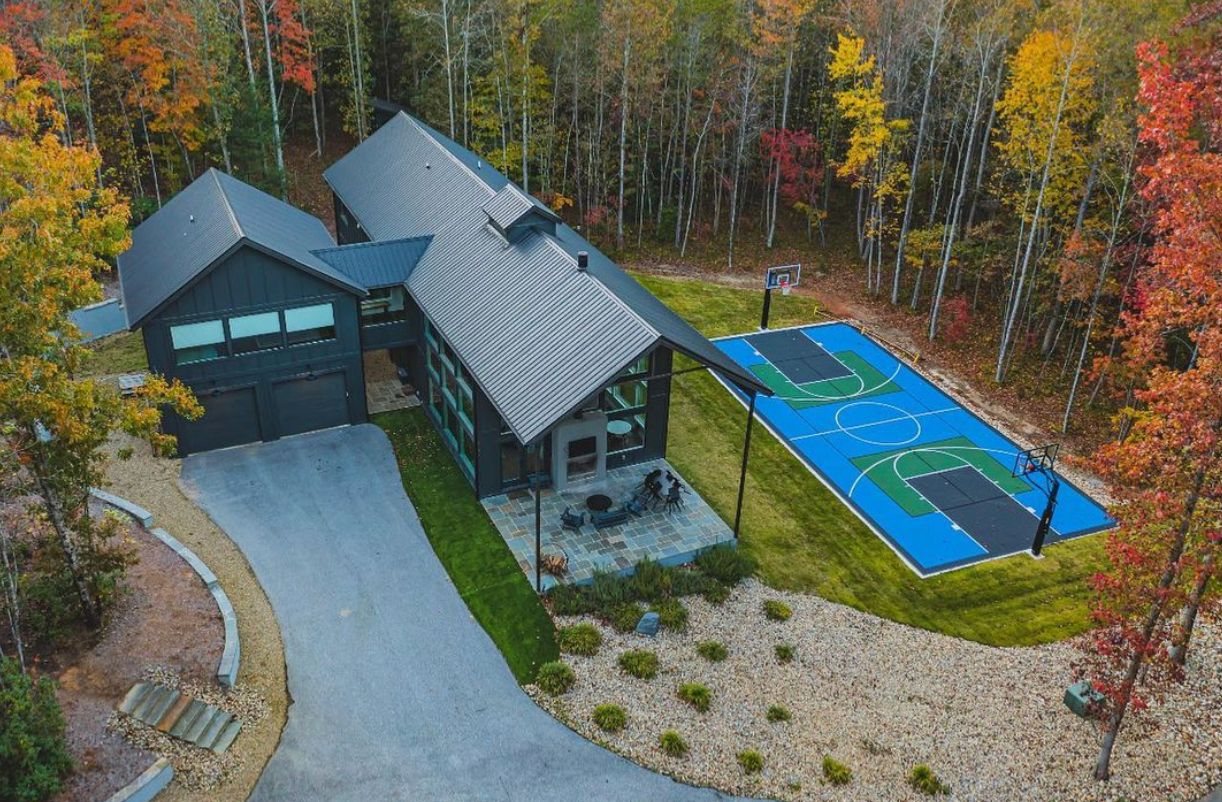 Aerial view of a custom backyard basketball and multi-sport court at a modern Carolina home in autumn